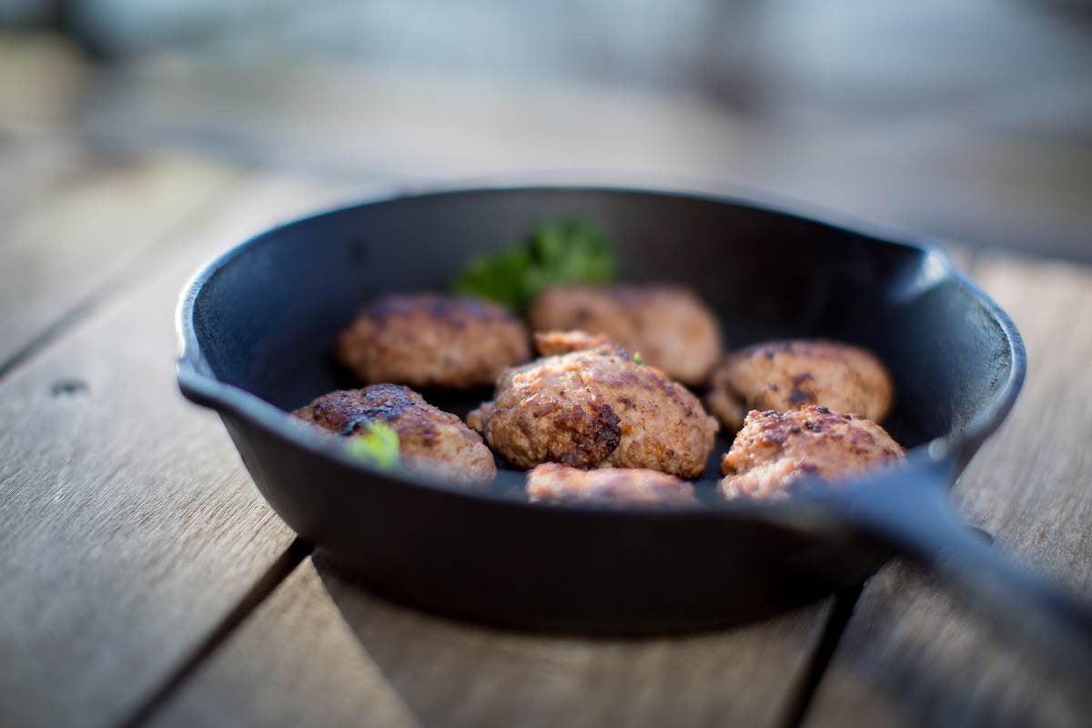 Load image into Gallery viewer, Maple sausage frying up in a cast iron pan
